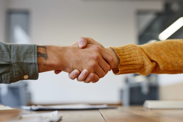 a man with a tattoo on his arm shakes hands with a woman