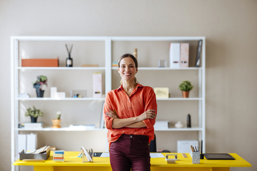 A woman standing in front of a desk to signify a career in legal operations.