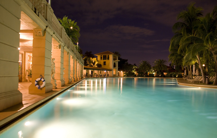 a large swimming pool is lit up at night